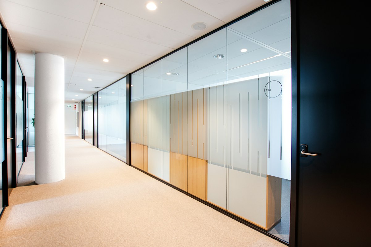 Gang met glazen wanden in bedrijfsgebouw